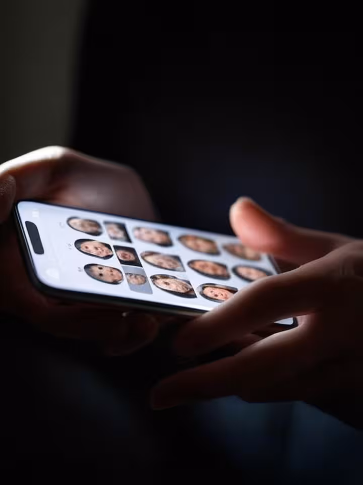 Woman's hands holding phone showing dating app matches, privacy lock icons overlaid, dramatic lighti